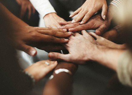 Many hands together in a pile - working together metaphor