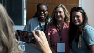 three school librarians pose while a four takes their picture with a smart phone