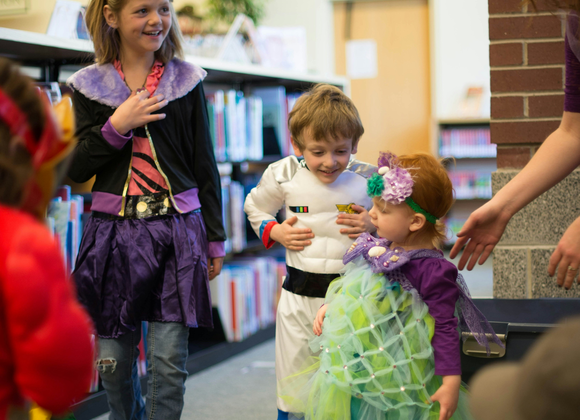 Kids celebrating a costume party in a school library