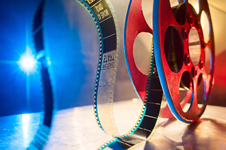 A colorful photo of a film reel and projector light