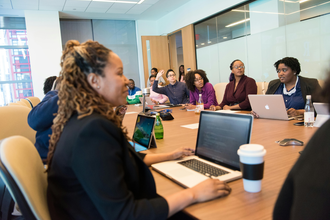 A group of people around a desk at a training session