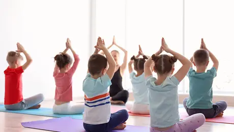 Six children doing yoga with female adult instructor.